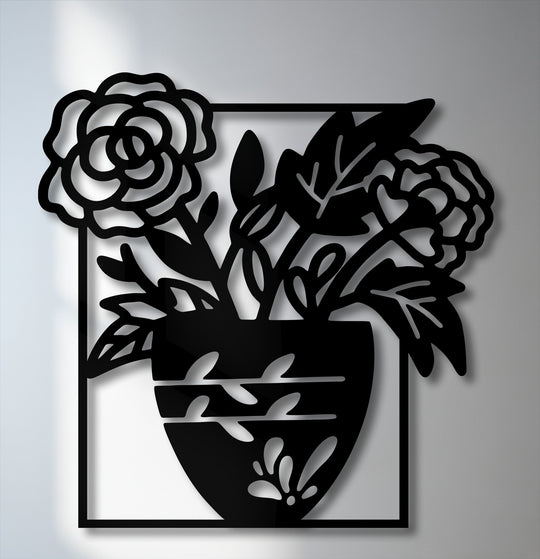 The intricate interplay of light and shadow highlights the bold floral vase silhouette in this striking metal art for wall, creating depth.