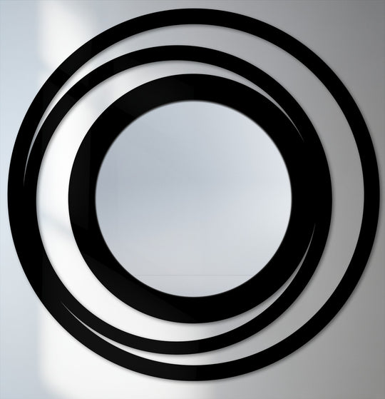 The brightest area highlights the circular design of the orbit ring floor bathroom mirror with its reflective center framed by bold black rings.