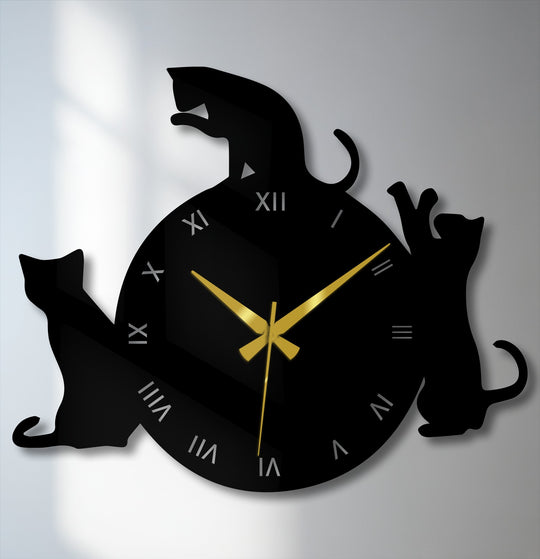 Foreground cat silhouette designs adorn this playful metal artwork clock, featuring prominent Roman numerals and sleek gold hands.