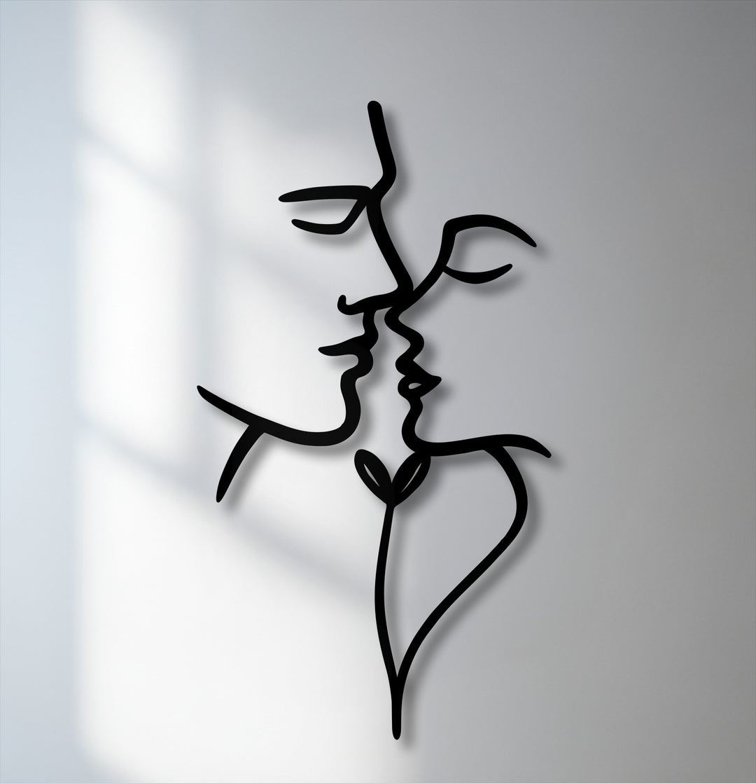 The smooth, matte black finish of this unique metal wall art featuring abstract kissing faces creates subtle visual depth.