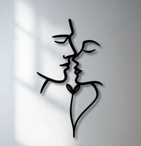 The smooth, matte black finish of this unique metal wall art featuring abstract kissing faces creates subtle visual depth.