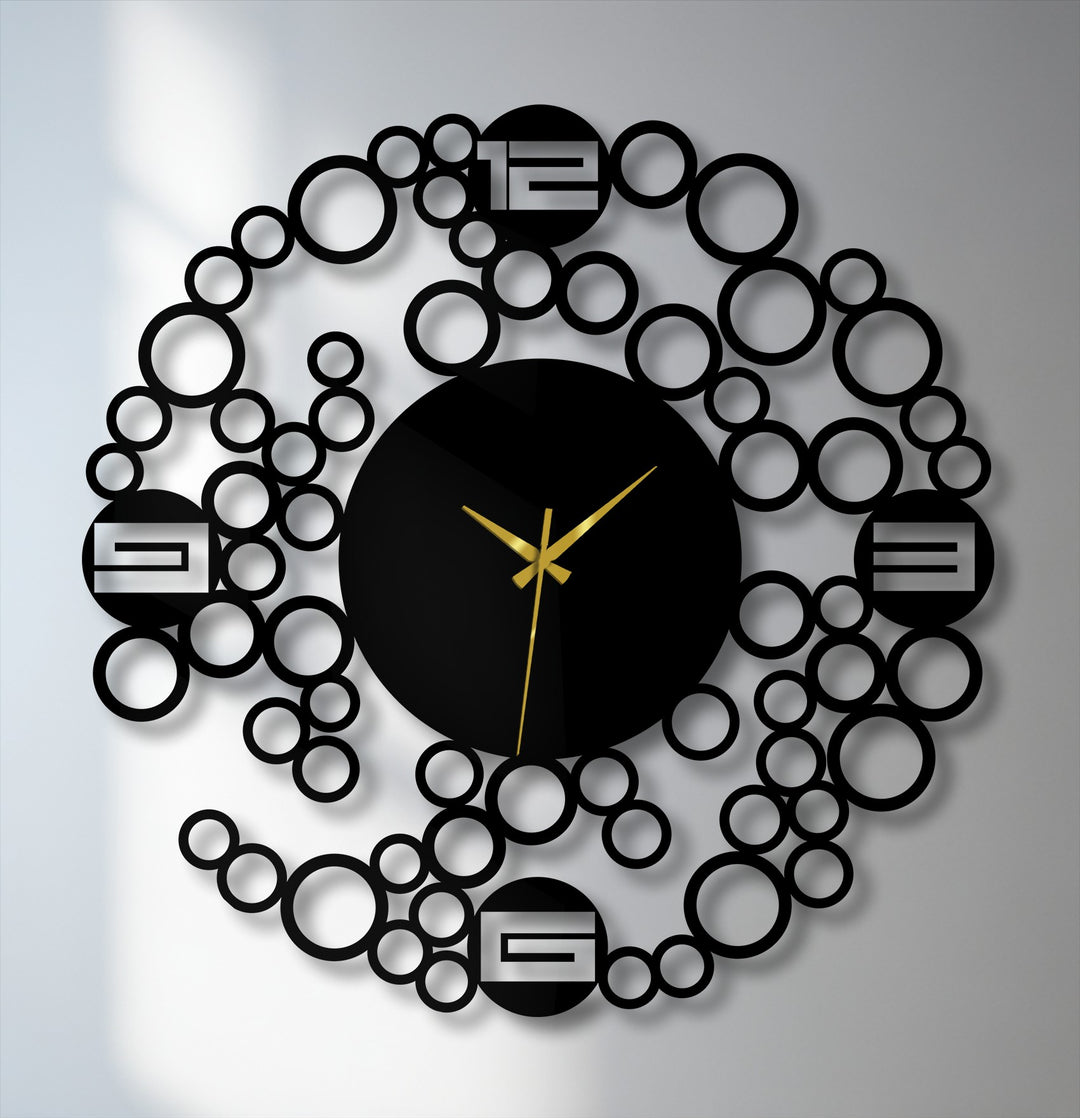 A modern decoration wall art clock features a central round black face with gold hands encircled by an abstract metal ring of varying-sized bubbles.