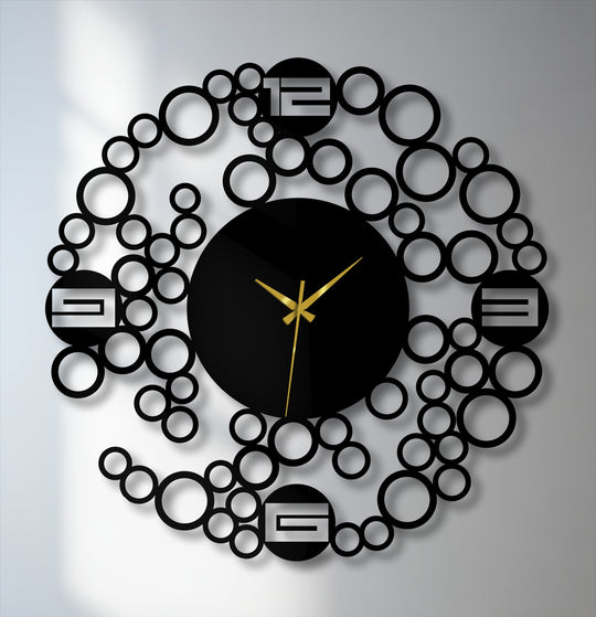 A modern decoration wall art clock features a central round black face with gold hands encircled by an abstract metal ring of varying-sized bubbles.