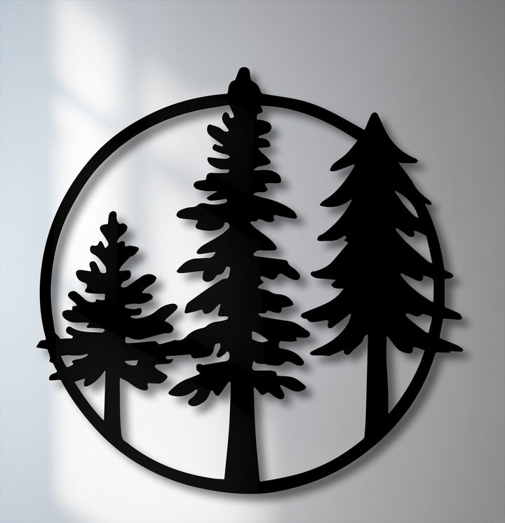 The prominent black silhouette of three evergreen pine trees within a circular frame makes for striking metal art for wall decor.