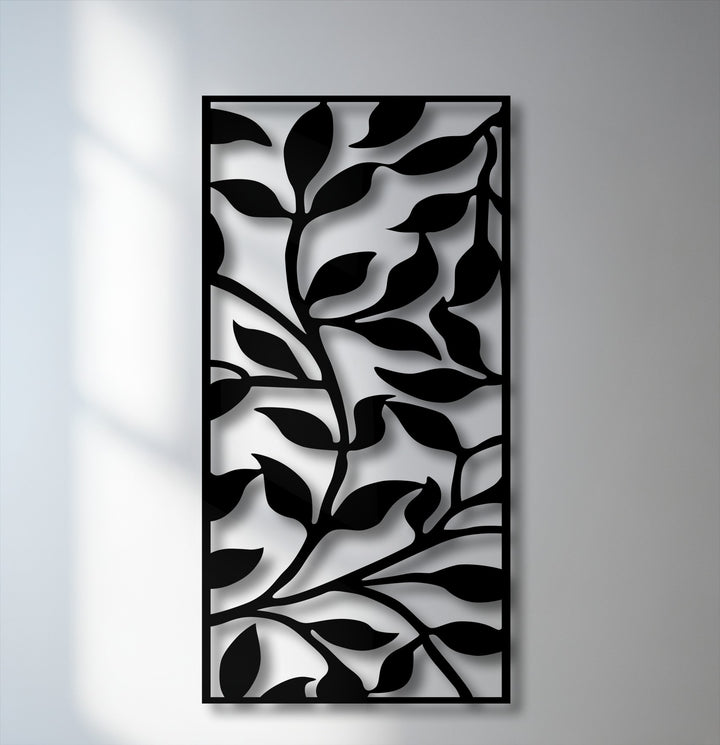The stillness of the modern botanical metal wall decor showcases an abstract black leaf branch pattern against a soft, sunlit wall.