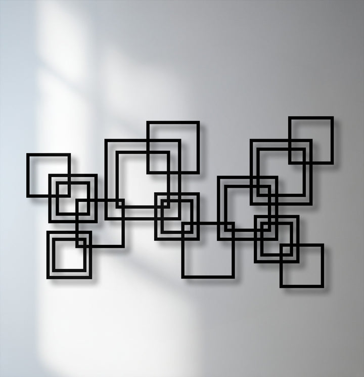 The stillness of the modern geometric metal artwork is captured by the static, black interlocking squares against a soft, sunlit wall.