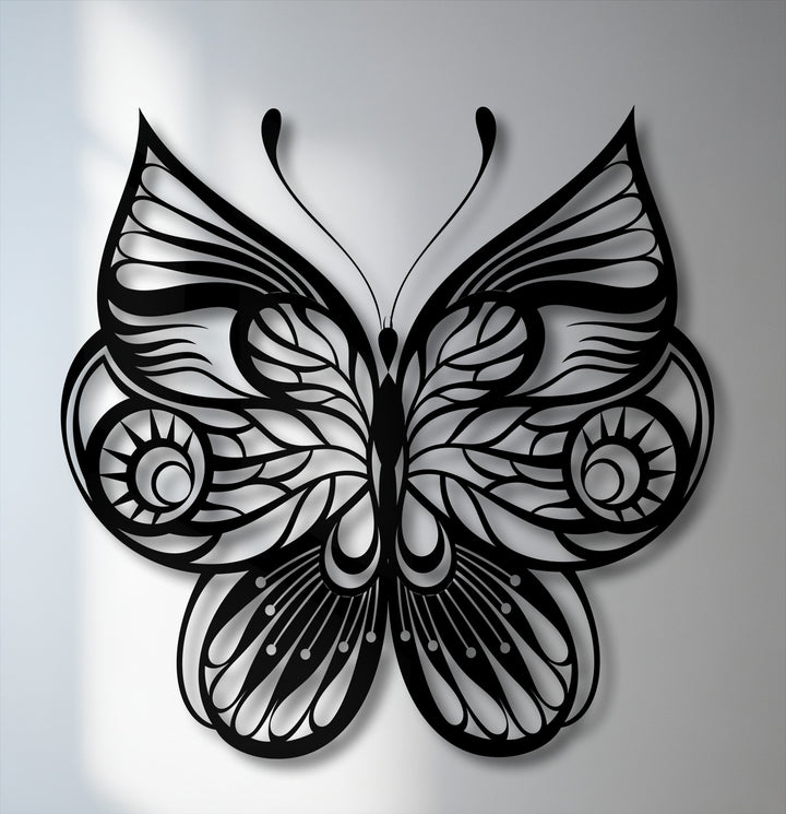 The soft, light gray background features subtle shadows cast by the unique metal wall art, an ornate decorative butterfly design.