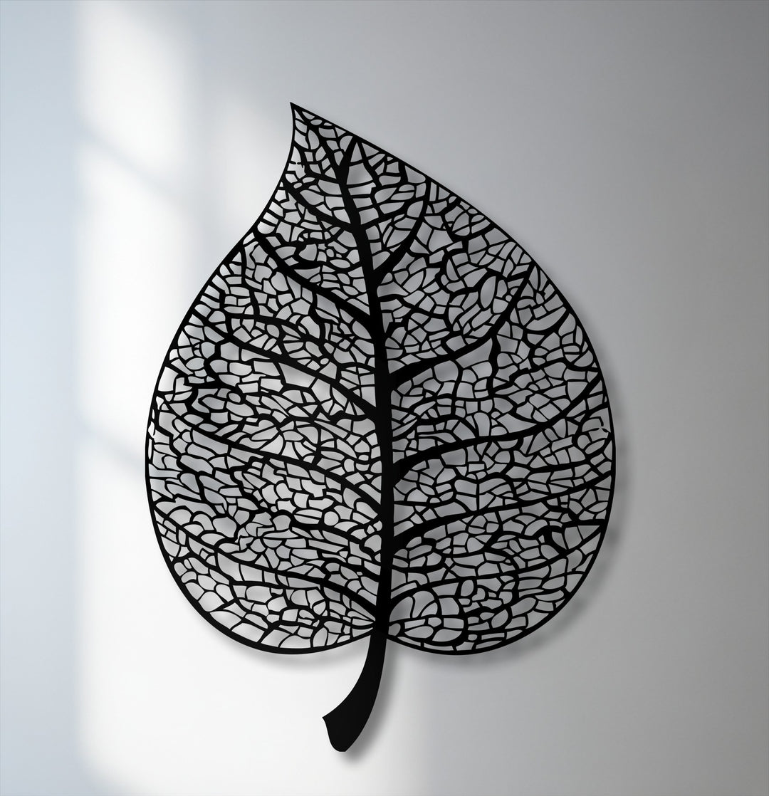 A serene mood emanates from this intricate black botanical leaf silhouette metal artwork, casting gentle shadows.