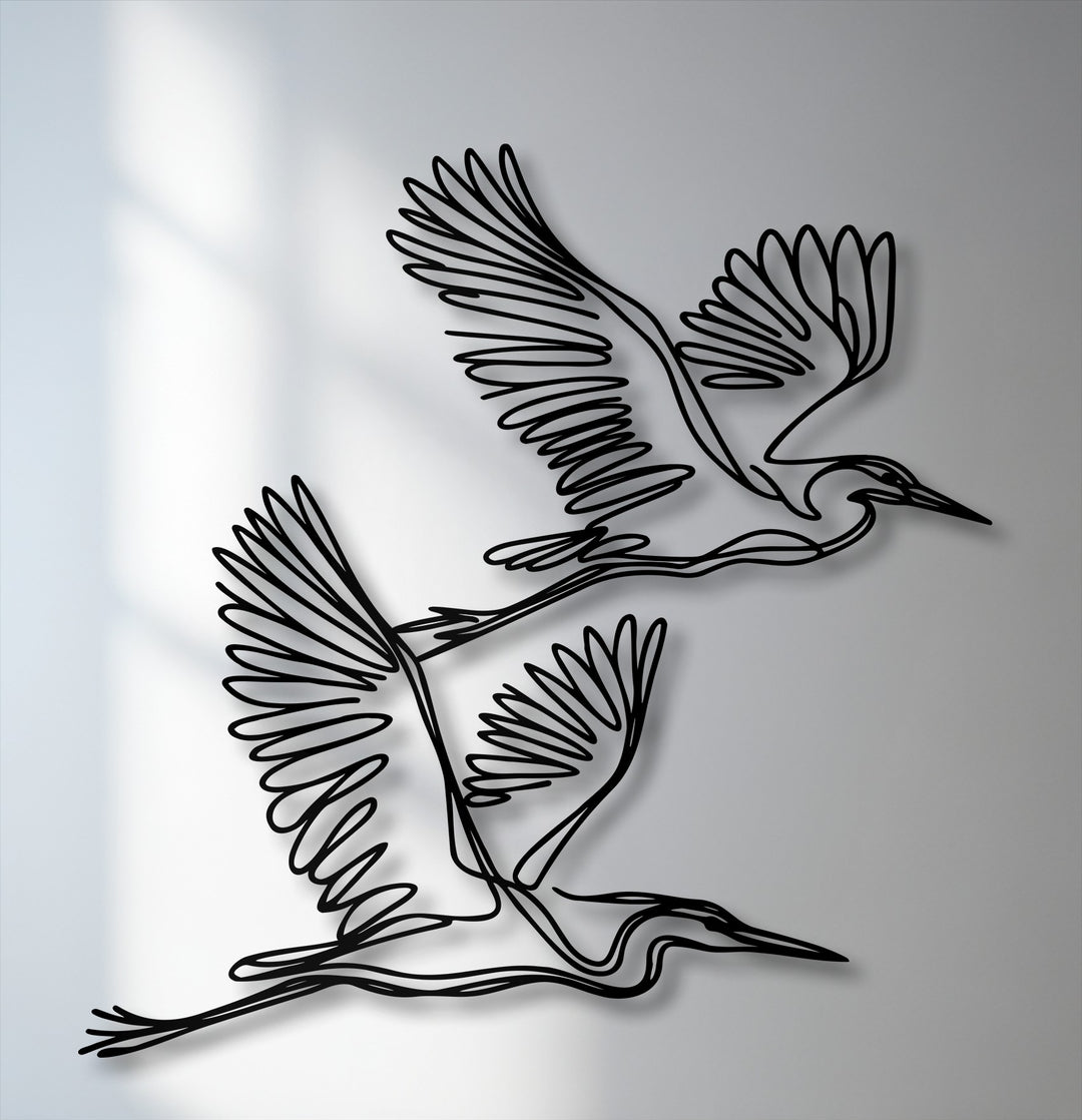 The softest element, the ethereal wall shadows, gently highlights the intricate details of the flying herons metal artwork.