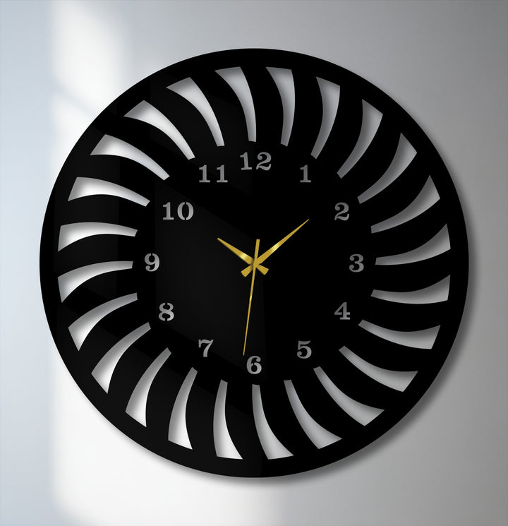 The unmoving, striking gold hands of this radial pattern metal artwork clock convey serene stillness against its modern black spiral design.