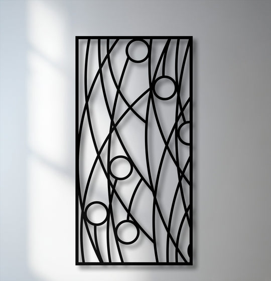 The background reveals a simple light grey wall and a brighter white wall with soft shadows, enhancing the unique metal wall art panel design.