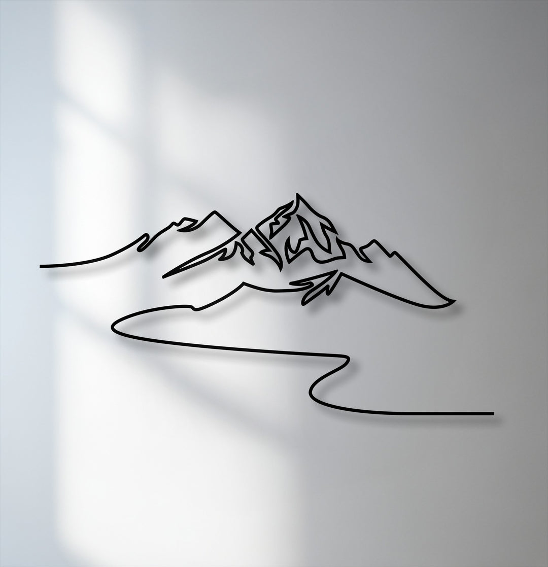 The brightest area illuminates the modern minimalist mountain metal art for wall, casting sharp shadows on the light gray wall surface.