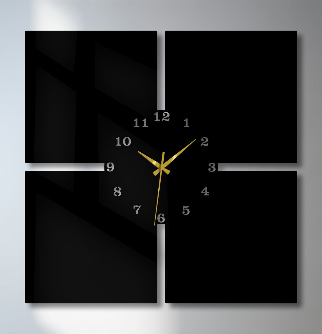 Crisp edges and panel borders define this modern 4-piece metal wall clock, a sleek black decoration wall art with gold hands.