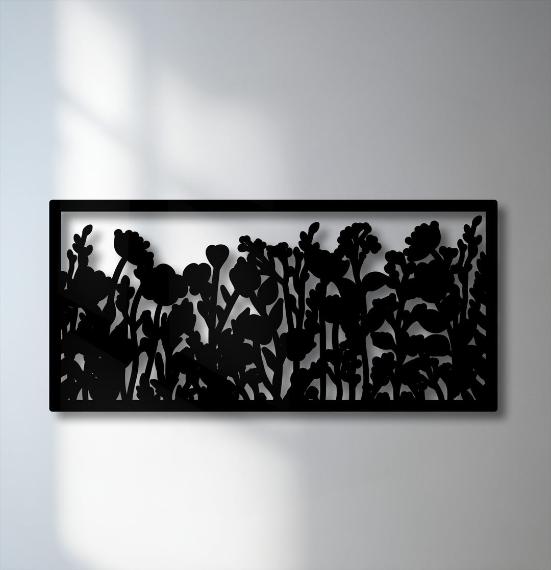 Smooth, matte black surface texture of a unique metal wall art panel featuring a framed wildflower botanical garden silhouette.