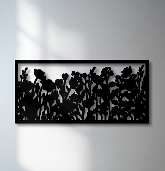 Smooth, matte black surface texture of a unique metal wall art panel featuring a framed wildflower botanical garden silhouette.