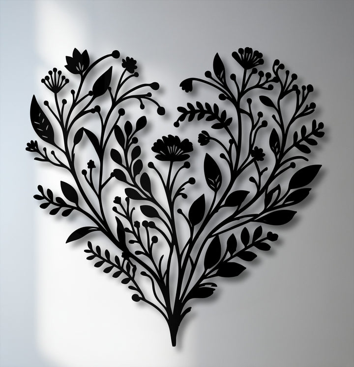 The darkest area reveals an intricate black botanical heart metal wall decor, featuring detailed floral nature designs.