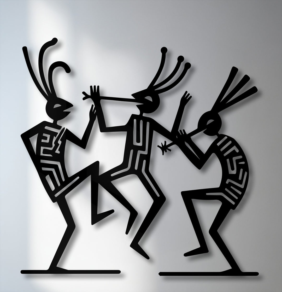 The smooth, matte surface texture of the black tribal dance figures in this unique metal wall art creates a striking contrast with the subtle sheen.