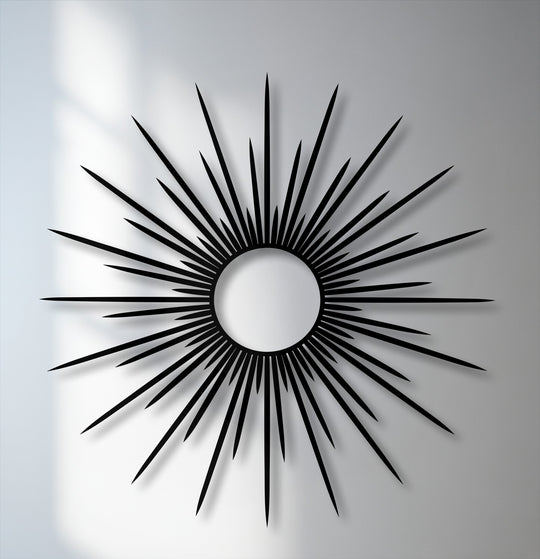 Evoking a bold and sophisticated mood, this radiant black sunburst metal wall decor features striking, elongated rays.