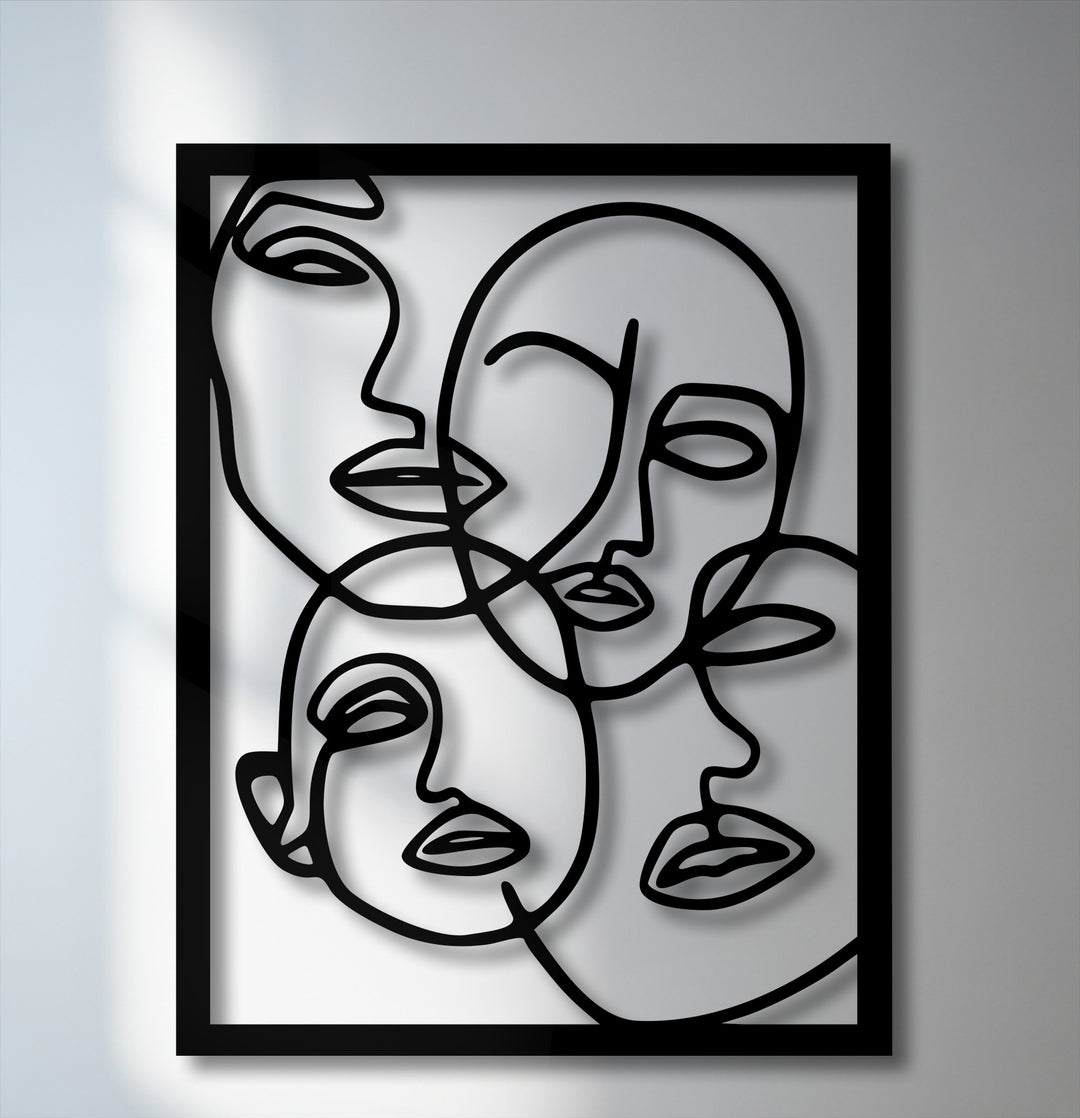 The matte black finish of this dimensional Abstract Faces Line Art metal wall decor creates striking shadows, enhancing its minimalist portrait design.