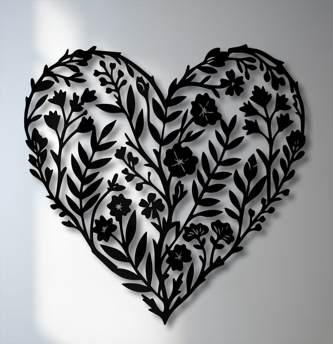 The unique metal wall art showcases a striking color contrast between the intricate black botanical heart silhouette and the soft, illuminated white background.