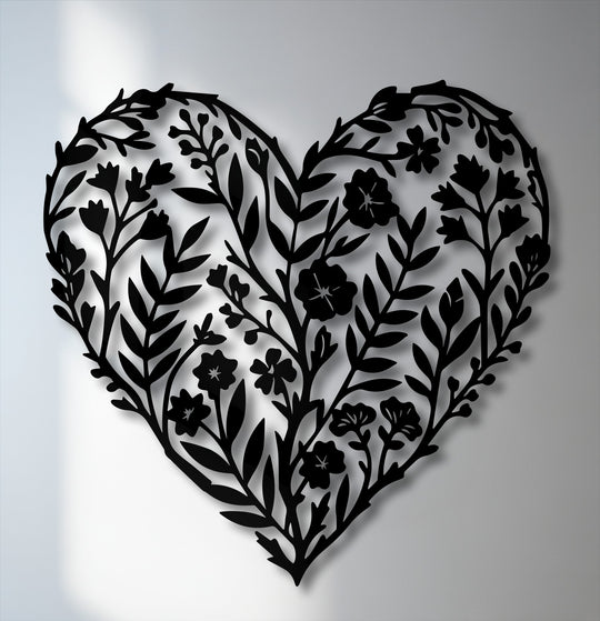 The unique metal wall art showcases a striking color contrast between the intricate black botanical heart silhouette and the soft, illuminated white background.