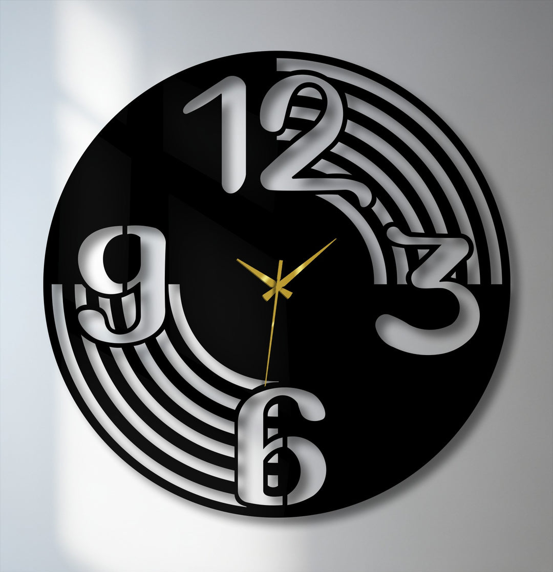 The sleek, contemporary mood of this unique metal wall art is enhanced by its modern black clock face with bold numbers and elegant gold hands.