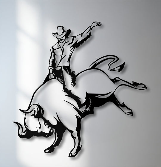 The cool color temperature of this metal artwork highlights a dynamic cowboy bull riding silhouette with sharp black and white contrasts.