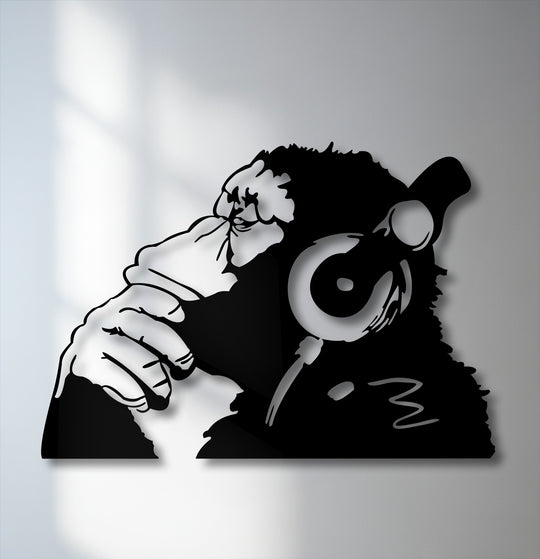 The brightest area highlights the striking black silhouette of an urban monkey with headphones, a unique piece of metal artwork.