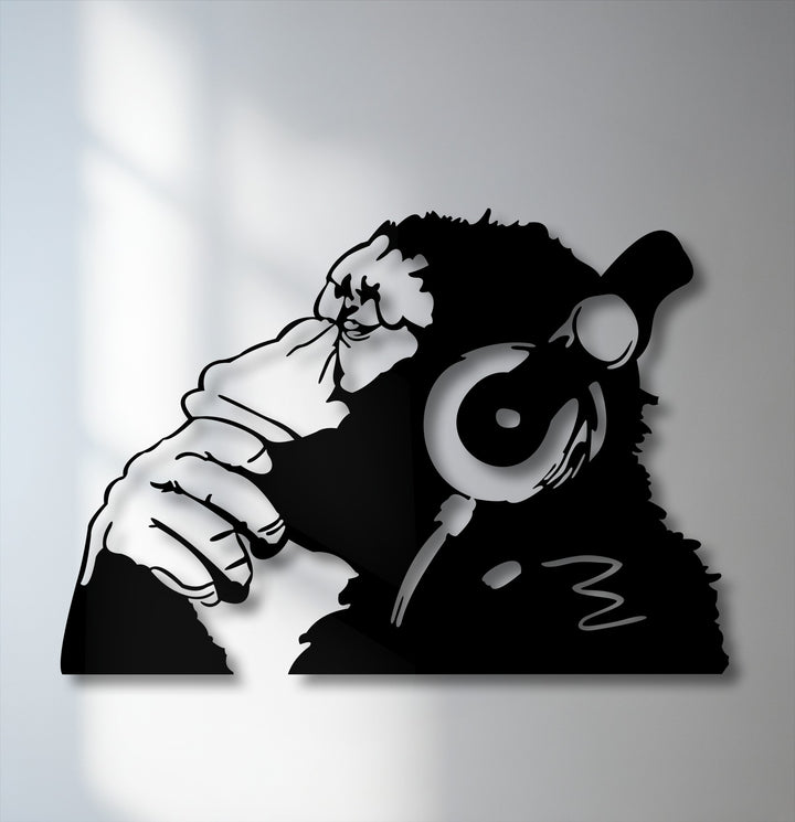 The brightest area highlights the striking black silhouette of an urban monkey with headphones, a unique piece of metal artwork.