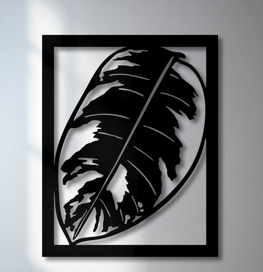 The distinct layering effect of sleek black metal art for wall, featuring a minimalist tropical monstera leaf design within a frame, creates depth.