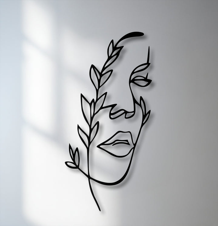 Geometric abstract lines form a unique metal wall art featuring a minimalist female face intertwined with flowing botanical elements.