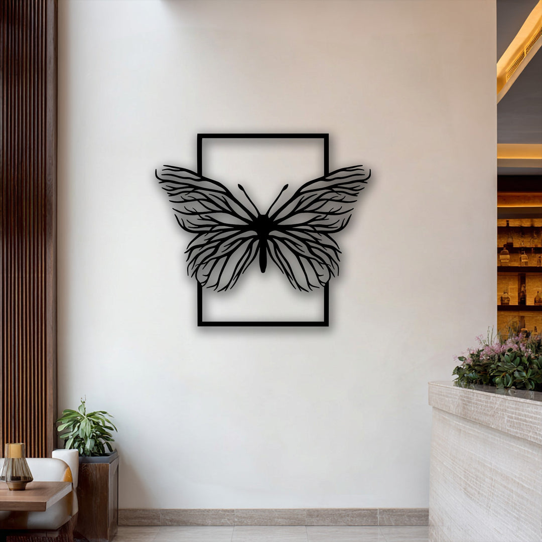 The striking negative space defines the delicate branches of the butterfly metal artwork, making the ethereal silhouette pop against the neutral wall.