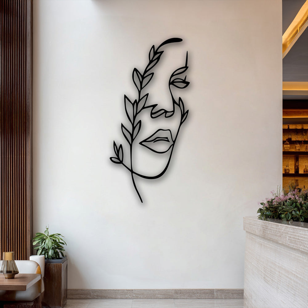 The negative space defines the elegant form of a minimalist female line art in this unique metal wall art, adorned with delicate botanical elements.
