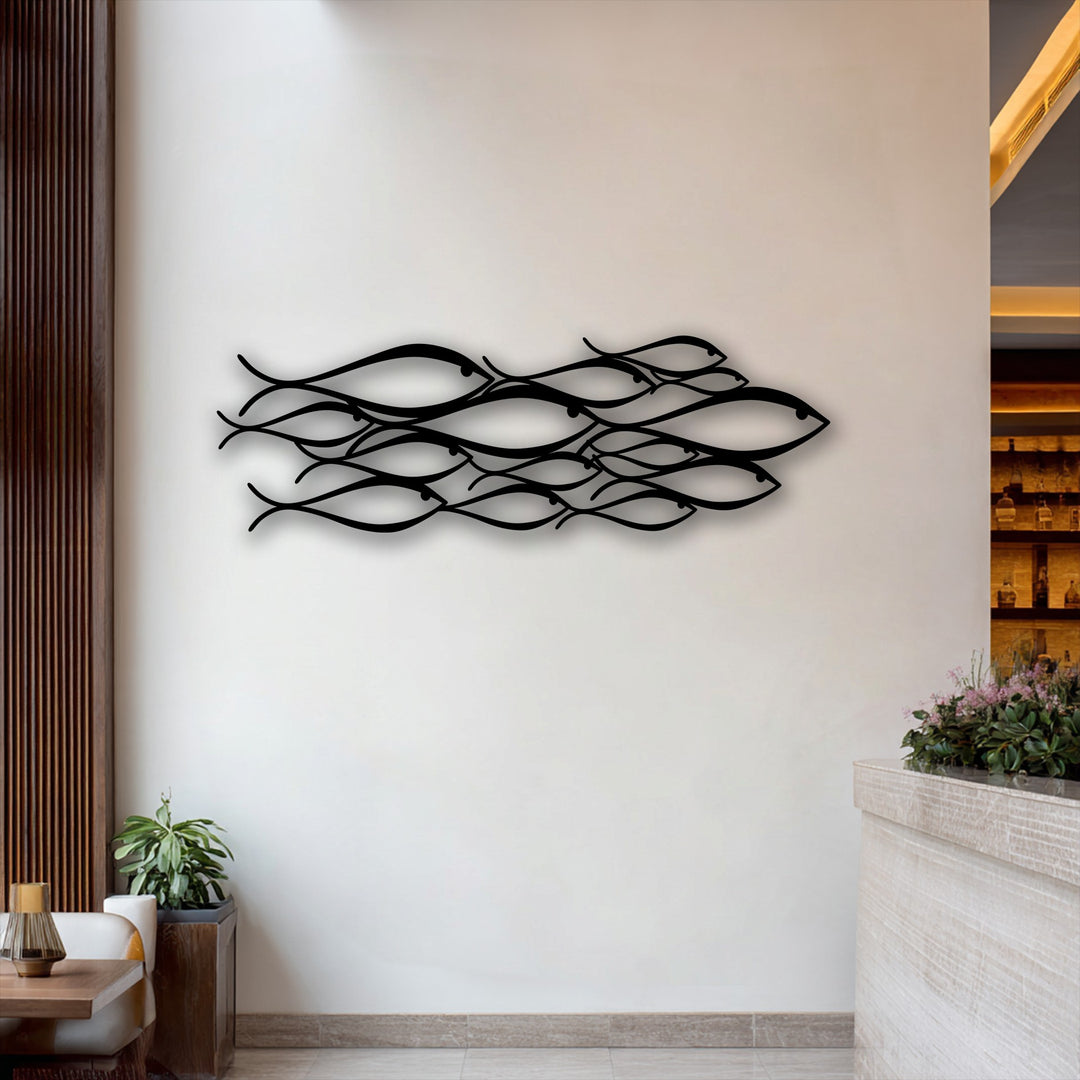 A crisp white wall displaying a sleek black minimalist abstract school of fish metal decoration wall art.