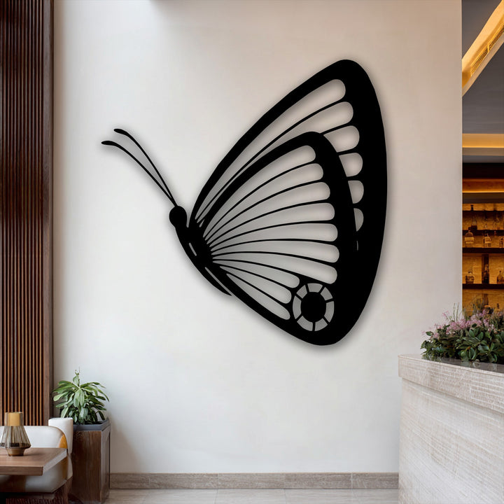 Graceful winged elegance of a butterfly in flight, captured as unique metal wall art, suggesting a dynamic flutter on the wall.