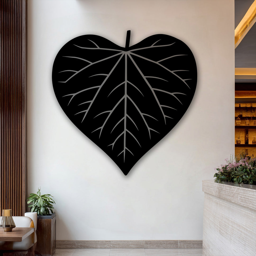 Delicate pink blooms and lush green foliage softly frame the sleek heart-shaped leaf silhouette decorative metal art.