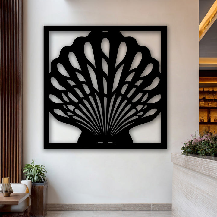 Negative space within the unique metal wall art beautifully forms the intricate fan-like details of a modern seashell frame on a light wall.