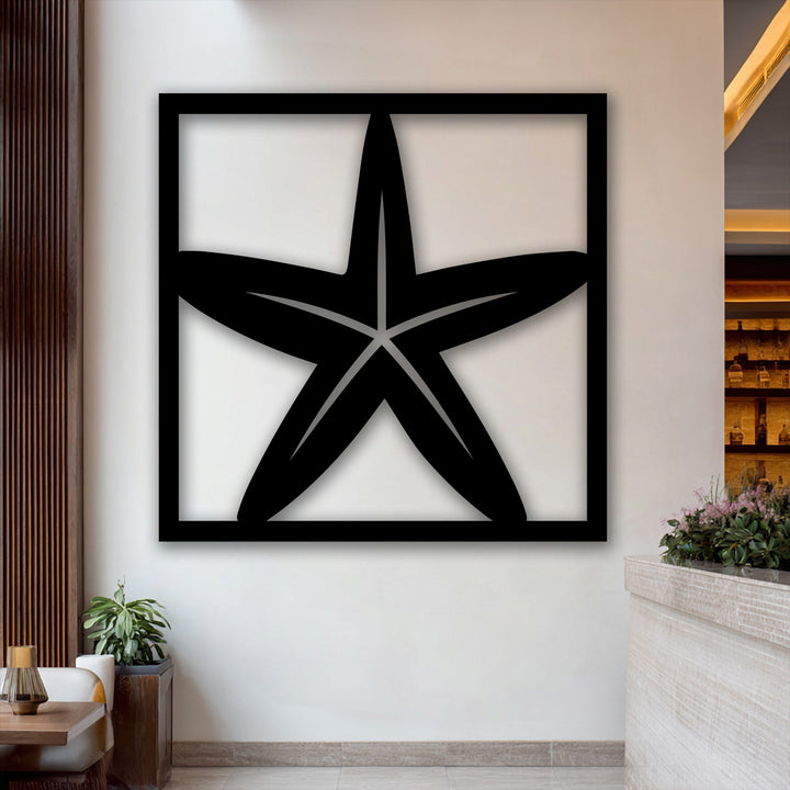 The play of light and shadow highlights the distinct form of the unique metal wall art, creating depth around the starfish frame.