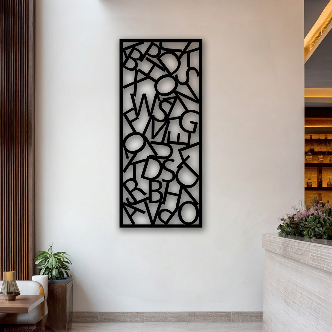 The realistic detail of the black decorative metal art reveals crisp abstract typography and modern letter composition decor on a white wall.