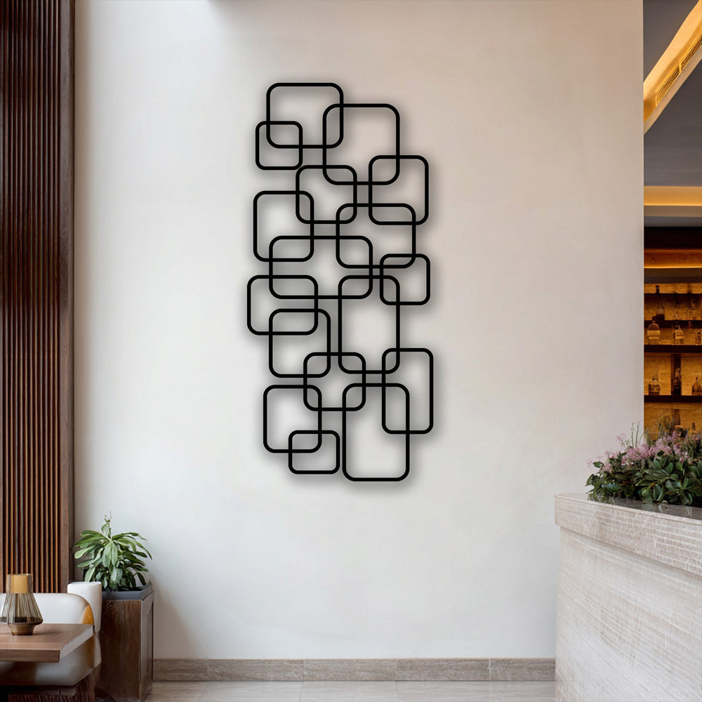 Soft purple blossoms and lush green foliage gently enhance the striking modern geometric metal art for wall with interlocking squares.