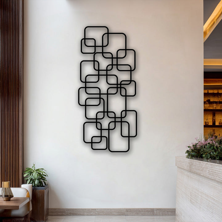 Soft purple blossoms and lush green foliage gently enhance the striking modern geometric metal art for wall with interlocking squares.