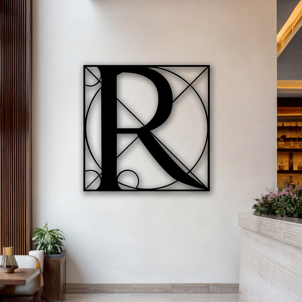 Its rectangular orientation and intricate geometric shape define this unique metal wall art, prominently featuring a stylish letter R.