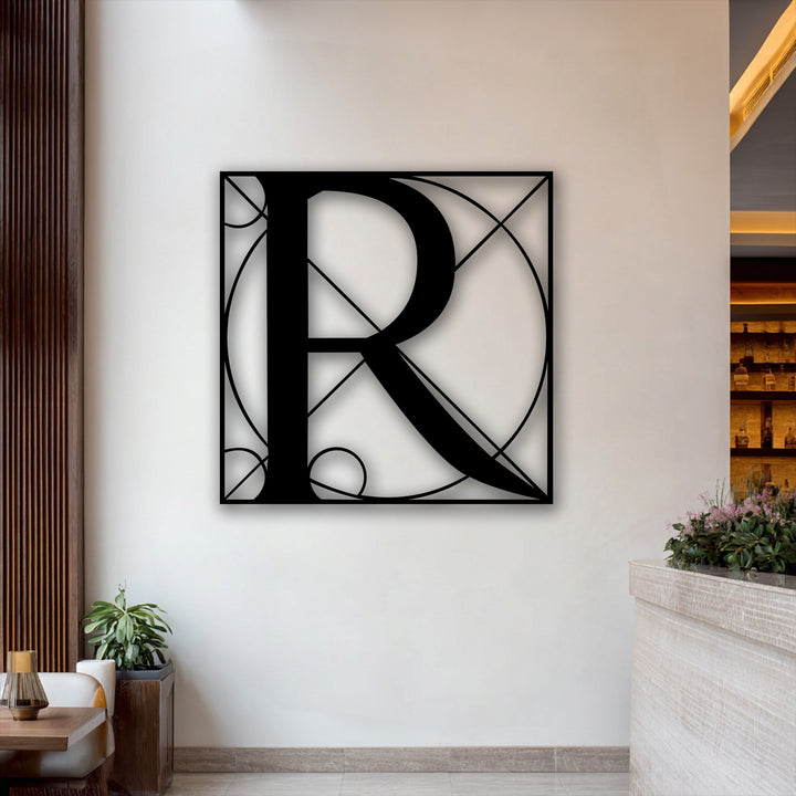 Its rectangular orientation and intricate geometric shape define this unique metal wall art, prominently featuring a stylish letter R.