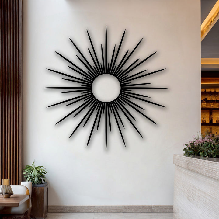 The focal point is a striking black radiant sunburst metal art for wall, featuring a modern abstract circle design on a crisp white wall.