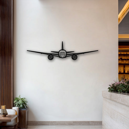 A unique metal wall art of an airplane silhouette adds depth to a white wall, layered between wood and a distant bar.