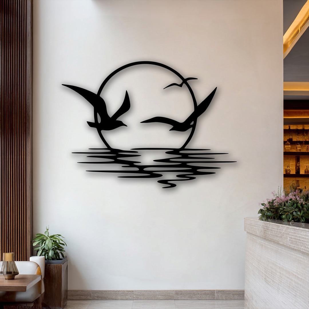The matte black finish of this unique metal wall art creates a striking silhouette of soaring seagulls at sunset.