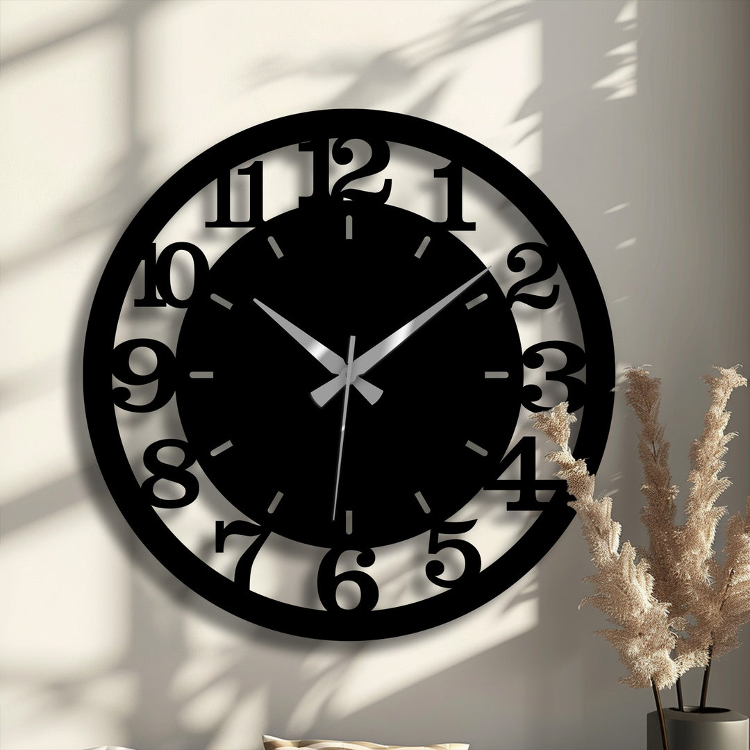The bold black metal of the modern numbered wall clock, a striking and loud element, makes it a piece of unique metal wall art.