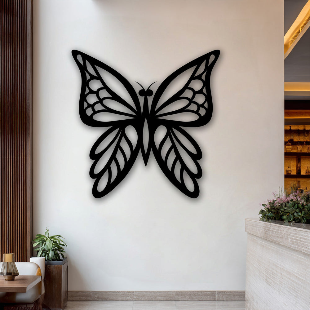 Symmetrically shaped black butterfly decorative metal art with elegant wings oriented centrally on a light wall.