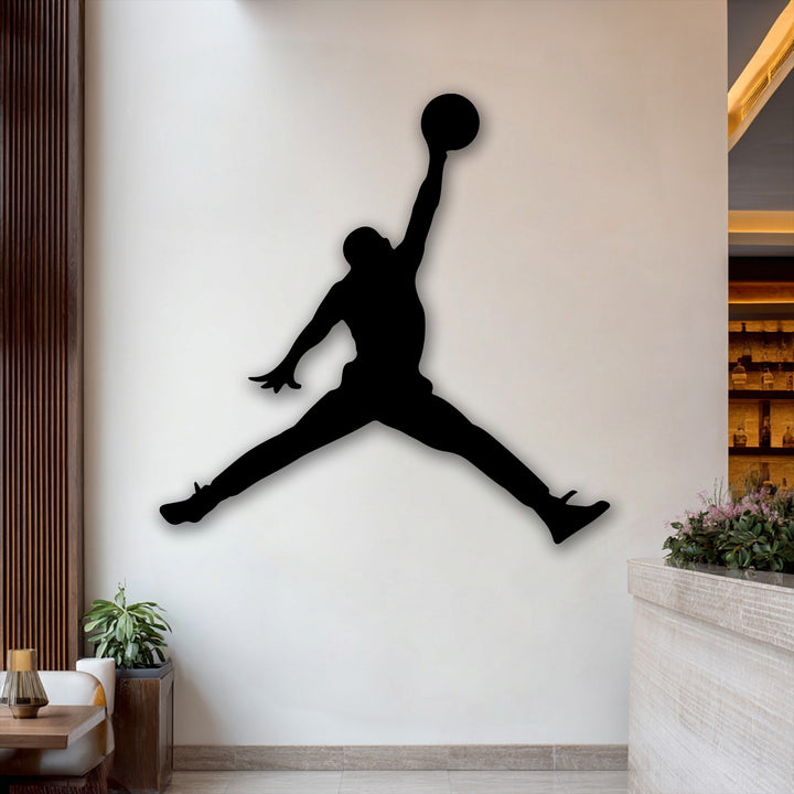 The layering effect is evident in the bold black silhouette of a basketball jump player, creating a unique metal wall art piece with a subtle shadow.