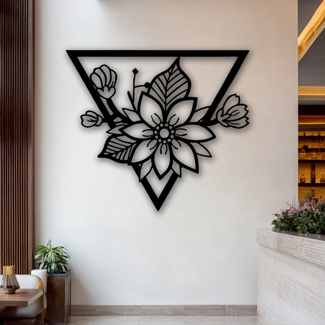 Negative space beautifully outlines the intricate floral patterns within the modern triangle frame of this decorative metal art.